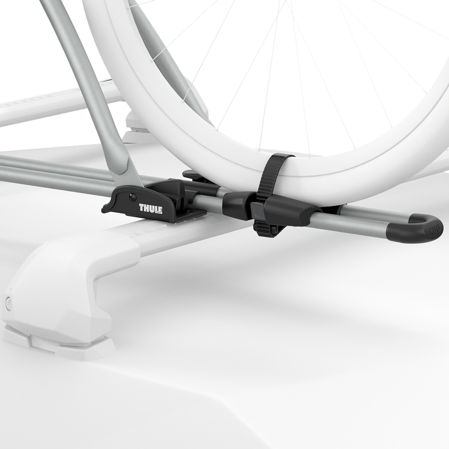 Close-up ghosted illustration showing the aluminum Thule FreeRide securing the bicycle wheels to the roof rack.